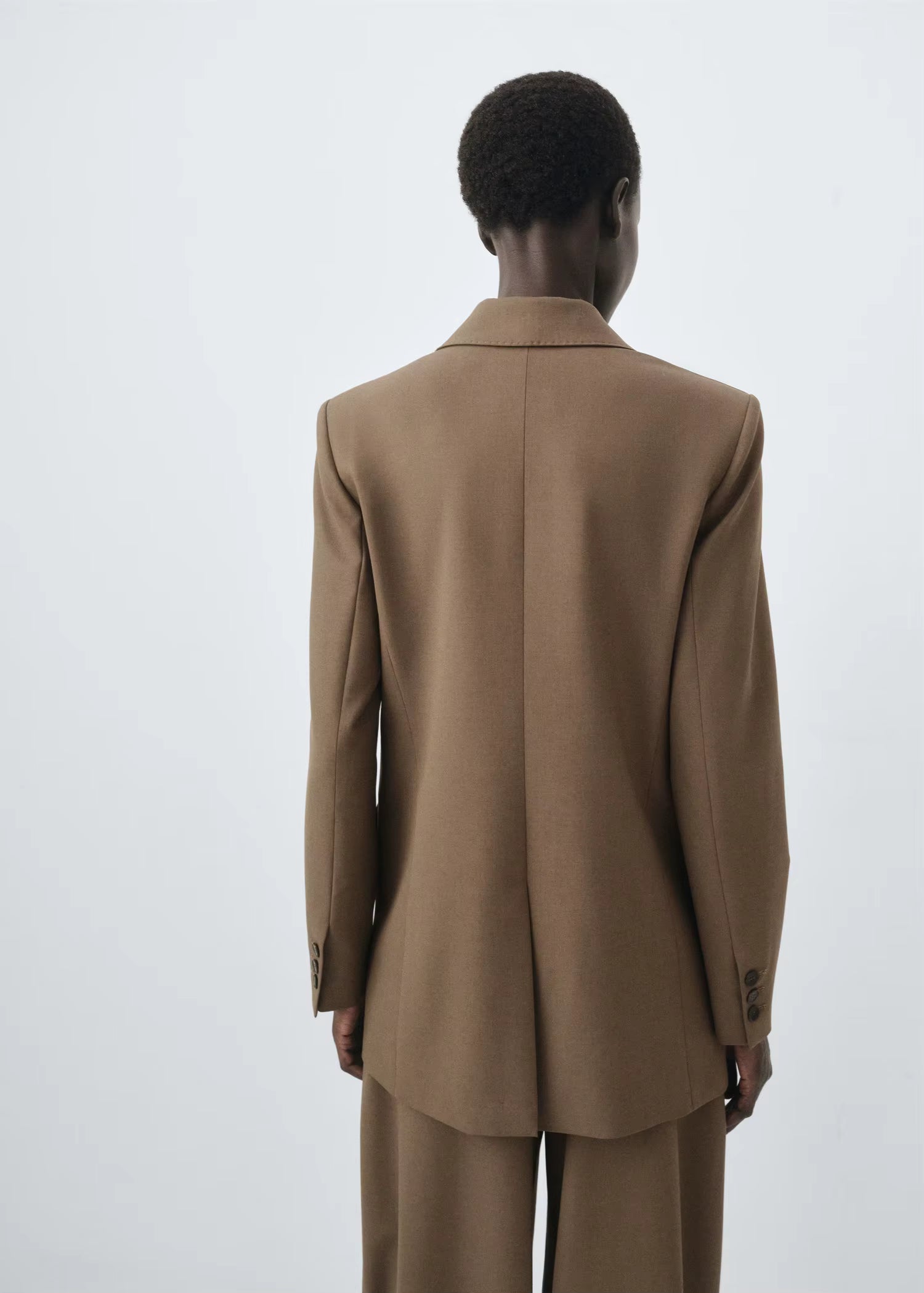 Structured women’s tailored jacket with a peak lapel shoulder design.