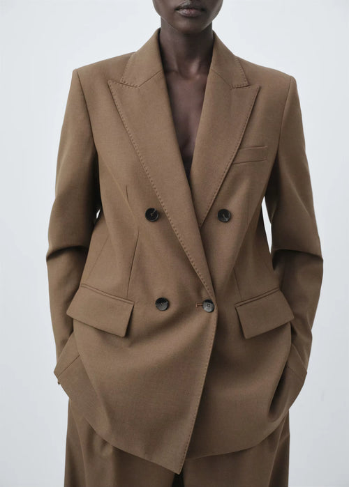 Structured women’s tailored jacket with a peak lapel shoulder design.